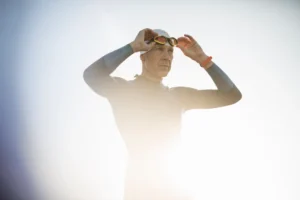 a swimmer in a wetsuit and swimming hat adjusting 2023 11 27 05 14 22 utc 1.webp